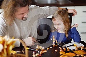 Father and his kid making chestnuts creatures