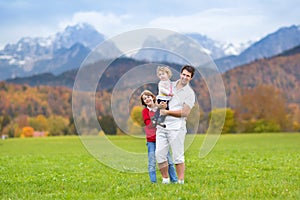 Father with his kids in field in snow mountains