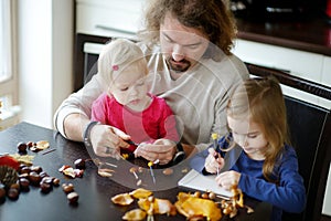 Father and his kids making chestnuts creatures