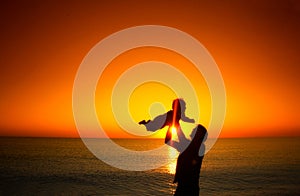 Father and his little baby son play on sunset beach. Family vacation on the sea.