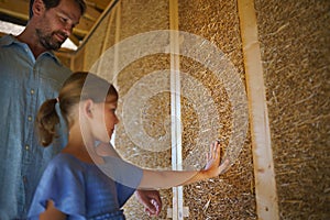 Father with his little daughter checking their unfinished wooden house, diy eco-friendly homes concept.