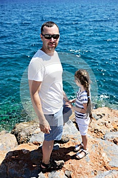 Father and his little daughter standing on rocks