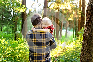 Father and his little son during the hiking activities in forest at sunset