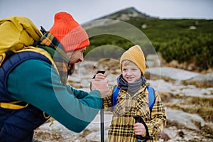 Otec se svým malým synem společně turistiku v horách.