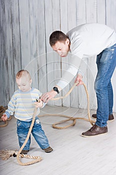 Father and his little son play with rope