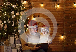 Father with his little son reading a magic book in cozy living room