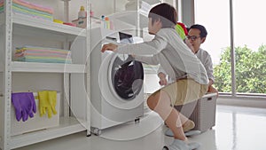 Father with his son is doing laundry in washing machine at home together for family housework togetherness concept.