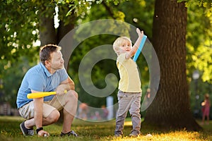 Father and his son playing baseball in park.