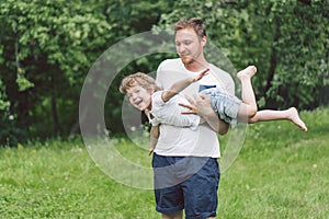 Father and his son playing and hugging in outdoors. Concept of Father`s day.