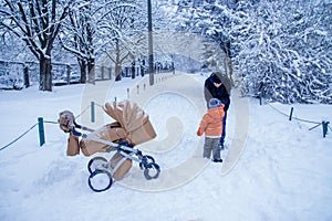 Father and his son playing outside, winter forest on the background, snowing, happy and joyful