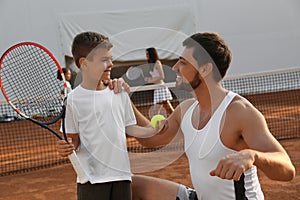 Father with his son on tennis court