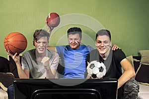 Father with his sons watching sport on television