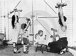 Father and his three children having a workout with dumbbells