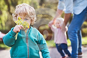 A father with his toddler children outside on a spring walk.