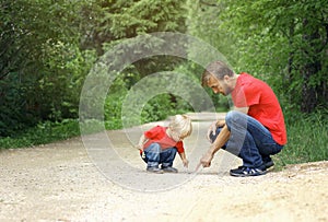 Father and his toddler son found the insect and inspect it. Kid exploring nature concept. Copy space