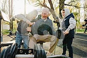 Father with his two sons on an outdoor sports ground in the park