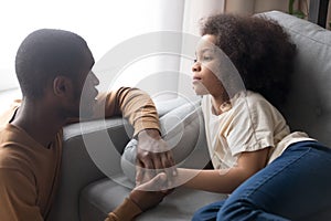 Father hold hand little daughter lying on sofa feels unwell