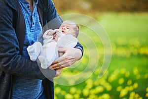 Father holding 4 weeks old baby girl in his arms