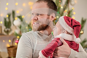 Father holding a baby Santa Claus celebrate Christmas