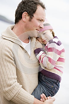 Father holding daughter at beach