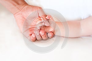 Father holding the hand of his new born son