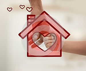 Father holding hands with child and illustration of house indoors. Adoption concept