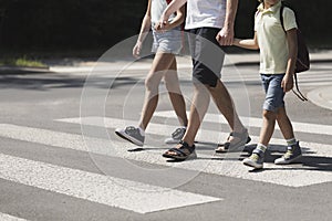 Father holding hands with his kids while on pedestrian crossing