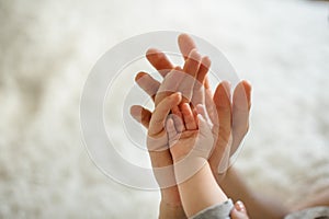 Father holding hands of his wife and their little cute daughter