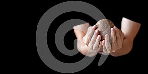 Father holding head of his newborn baby in hands on black background. Loving father hands holding cute sleeping newborn baby child