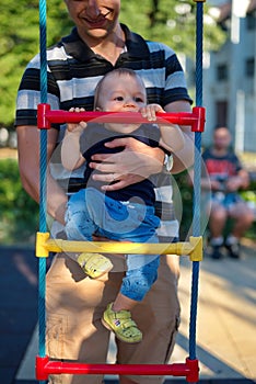Father holding his little baby boy on playground