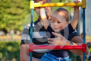 Father holding his little baby boy on playground