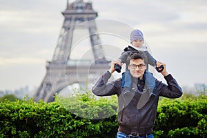 Father holding his son on shoulders near the Eiffel tower