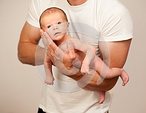 Father holding new born baby on his arm photo