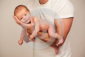 Father holding new born baby on his arm