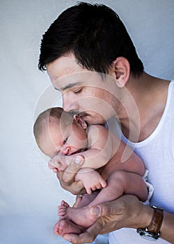 Father holding newborn baby up close to his face