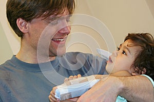 Father holding sick baby in hospital