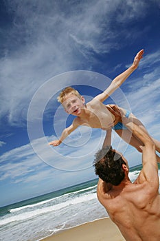 Father holding son by the shore