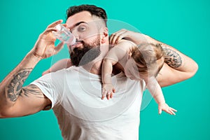 Father holding and taking care of little infant baby, feeding from bottle.