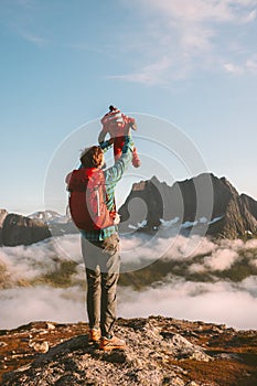 Father holding up child family travel vacations with infant baby hiking