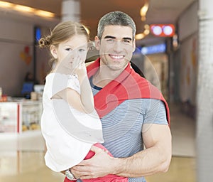 Father holding young daughter up at waist height