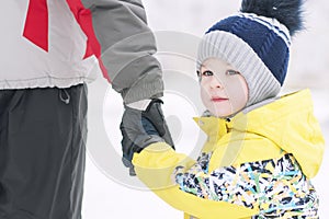 Father holds the boy`s hand in winter clothes, winter, family, hand in hand, lifestyle