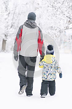 Father holds the boy`s hand in winter clothes, winter, family, hand in hand, lifestyle