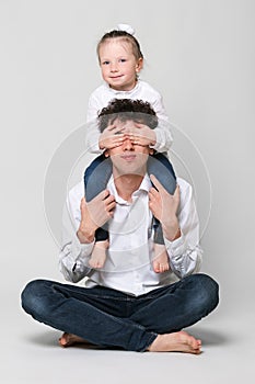 Father holds his daughter on his shoulders. Girl closed his eyes. The concept of happy parenting and happy childhood. On white