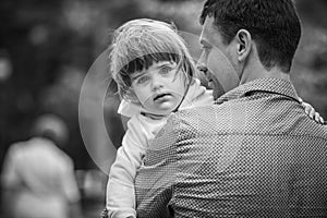 Father holds the little girl in her arms. black and white