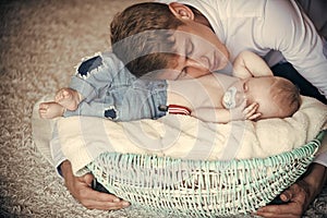 Father hug basket with baby son asleep