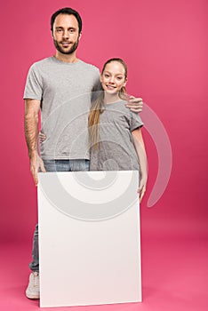 father hugging daughter and posing with blank placard, isolated