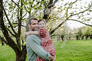 Father hugging his daughter in spring nature. Father's day concept.