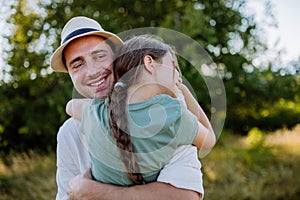 Father hugging his daughter in summer in nature. Father& x27;s day concept.