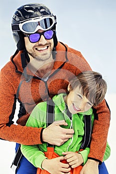 Father hugs his son affectionately in the snow