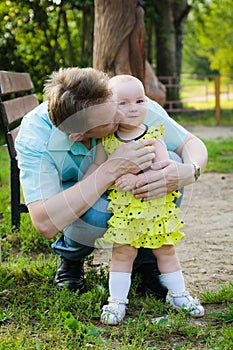 Father hugs a little daughter in a yellow dress